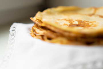 pancakes on a white tablecloth and plate a sunny day with sun glare