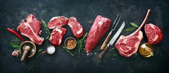 Foto op Plexiglas Verscheidenheid aan rauwe biefstukken om te grillen met kruiden en keukengerei © Alexander Raths