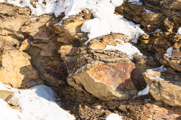 A piece of rock under the bright sun. Winter stones on the wall of the mountain. Just stones close to plan.