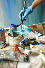 hand with paint brush touching palette