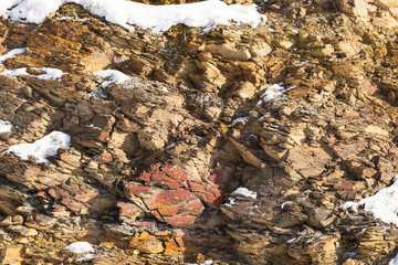 A piece of rock under the bright sun. Winter stones on the wall of the mountain. Just stones close to plan.