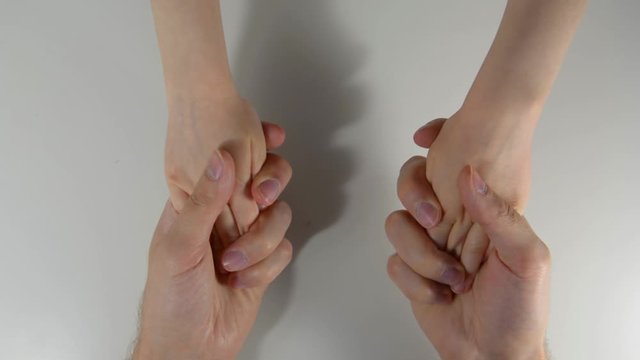 hands of a child squeeze the hands of an adult male. Baby and parents. On a white background children's hands