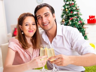 Young couple celebraring christmas with champagne