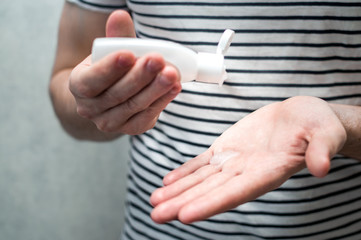 man puts a sanitizer on his hands. Hands and antibacterial gel close-up. The concept of protection against the virus and germs. Pandemic