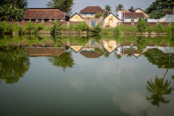 Fototapeta na wymiar Old houses reflecting on a pond, Kochi, Kerala, India
