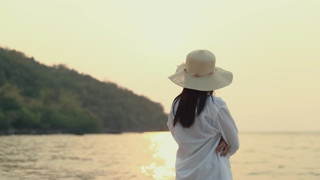 Attractive Asian woman feeling lonely while standing to look at view ocean beautiful sunset. Lifestyle travel holiday vacation summer concept.