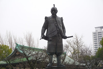 Bronze Statue of Toyotomi Hideyoshi stands guard with his sword in Osaka Castle, Japan on a cloudy...
