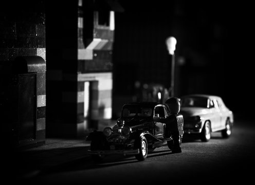The mood of the film noir - street photo on a micro scale using blocks and other toys. Intentional high grain and noise, selective focus (shallow depth of field).