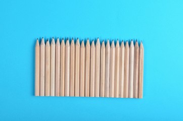 Lot of wooden pencils on blue paper background