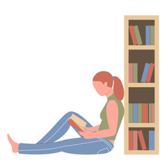 Reading girl sitting on the floor near a bookcase