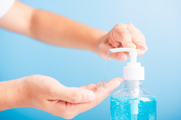 Close up woman applying press dispenser sanitizer alcohol gel pump to hand