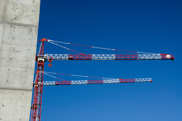 chantier de construction sobre épuré béton  grue rouge ciel bleu