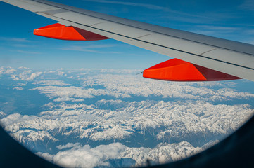 Naklejka na ściany i meble Aerial view of the snow-capped Alps from an airliner porthole