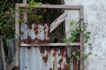 A wooden door with rusty iron cover in an abandoned place.