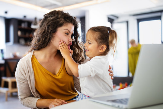 Mother at home trying to work with child distracting her