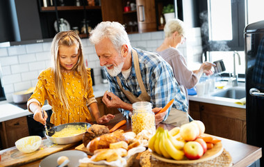 Smiling grandparents having breakfast with their granddaughter