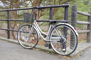 Fototapeta na wymiar ฺBicycle parked against wooden fence. Vintage bicycle with lock parking in the city