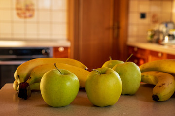 apples and bananas on the kitchen counter in the background oven and door