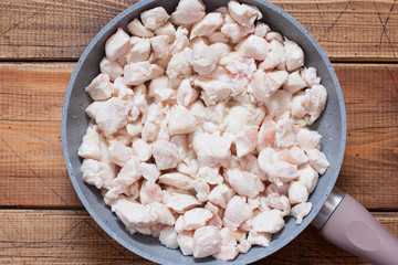 Step-by-step preparation of chicken fillet with mushrooms in sour cream sauce, step 2 - frying chopped chicken fillet, selective focus