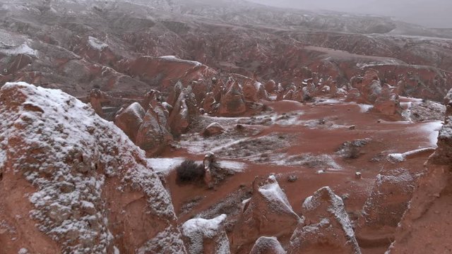 Fairy chimneys and cave houses surrounded by rock formations at Imaginary Valley in Cappadocia, Turkey. Tufa formations covered with snow in Devrent Valley in Cappadocia