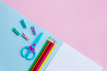 Office supplies on a pink and blue background. Work at home.