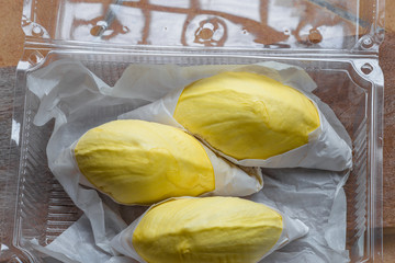 The close-up view of the fruit (durian) has an appetizing yellow color, arranged in a box for beauty, and available during the season.