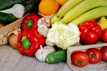 Against the background of a light countertop, tomatoes, cucumber, red pepper, garlic, iceberg salad.