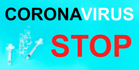 Words CORONAVIRUS STOP. Syringe and ampoule on a blue background.
