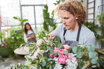 Florist mit Blumenschere beim Blumenstrauß kürzen