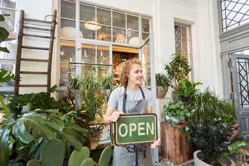 Florist mit open Schild vor Blumengeschäft