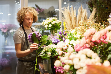 Junger Florist bei der Auswahl von Blumen