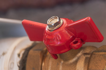 Close-up red used shut-off valve on central heating pipe