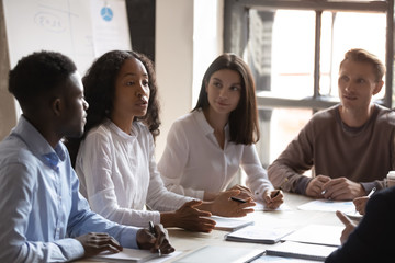 Fototapeta premium Multicultural businesspeople talk discuss business ideas at office briefing, African American female leader speak share thoughts brainstorm with diverse colleagues at meeting, collaboration concept