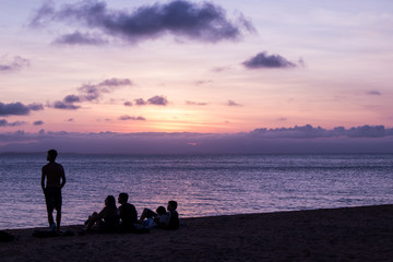 Silhouette of a group of friends by the beach