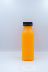 Front view of orange juice glass bottle isolated on white background