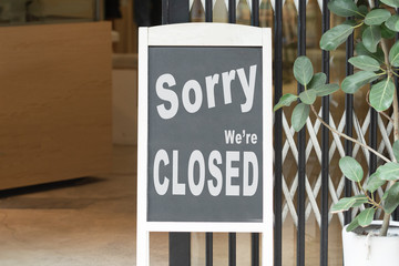 sorry we are closed sign hanging outside a restaurant, store, office or other