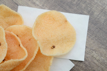 Pile of crunchy prawn crackers wooden board.