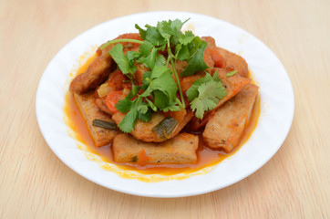 fried fishcake slices with stew sauce in plate