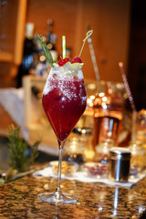 raspberry alcohol cocktail on the bar. red cocktail garnished with raspberries on bar background