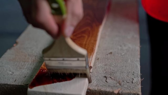 A molar brush paints a wooden surface
