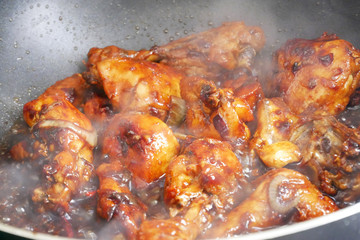 Fried chicken cooked with black soy sauce. The chicken pieces are fried over dry and then poured with soy sauce and onion.