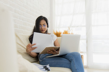 A young Asian woman working online from home.