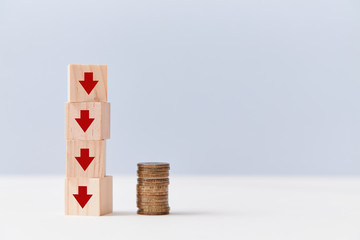 Financial crisis. Decrease in income. Bankruptcy, lack of money. Wooden cubes stack, arrows to down...