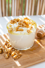 White yogurt cup with honey and nuts. Idea for a healthy and nutritious snack, low in fat.