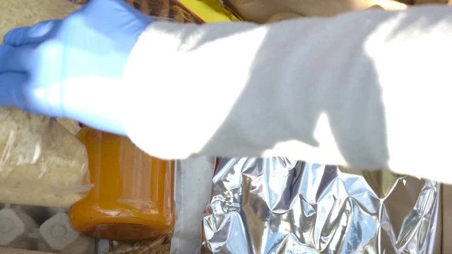 Volunteer putting food in a donation box, close up. Charity and donations
