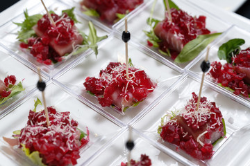 Slices of tuna sprinkled with grated boiled beets, decorated with lettuce.