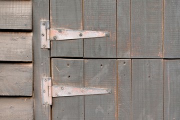 two old rusty metal hinges screwed to holding a stable door