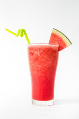 red watermelon smoothie in a tall glass decorated with a piece of watermelon