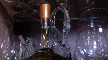 a bottle of cognac in the shape of a Swan on the shelf with glasses