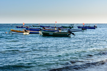 Naklejka na ściany i meble Fishing boats on the South China Sea coast, Da Dong Hai Bay at sunset.